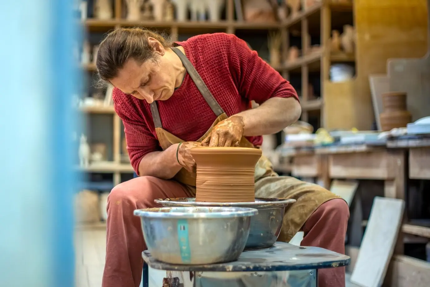 Ein Mann töpfert an der Töpferscheibe; ein Mann stellt Töpferwaren her; Tonmodellierung.